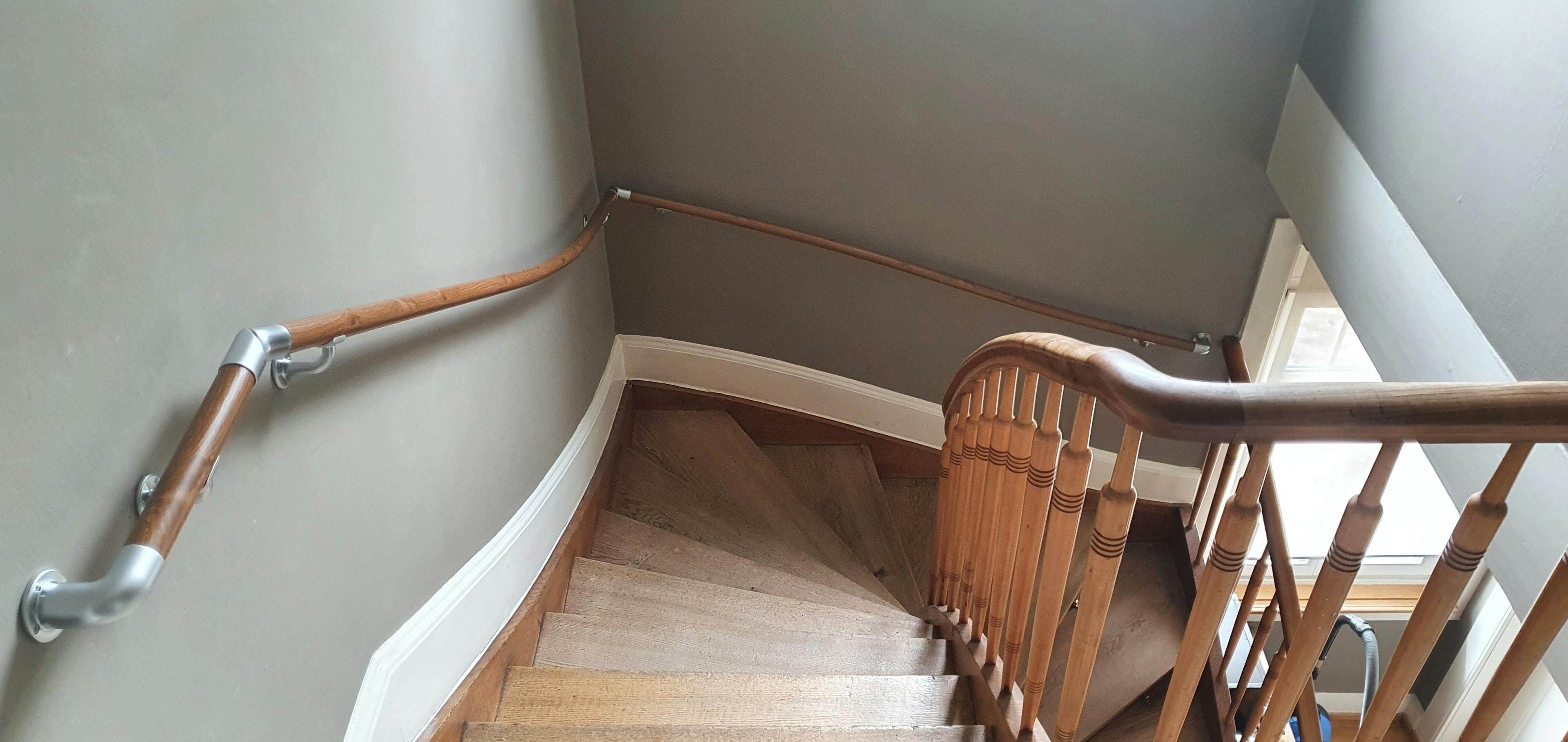 Zusätzlicher wandseitiger Handlauf an einer halbgewendelten Treppe (Bild: Flexo-Handlauf).&nbsp;