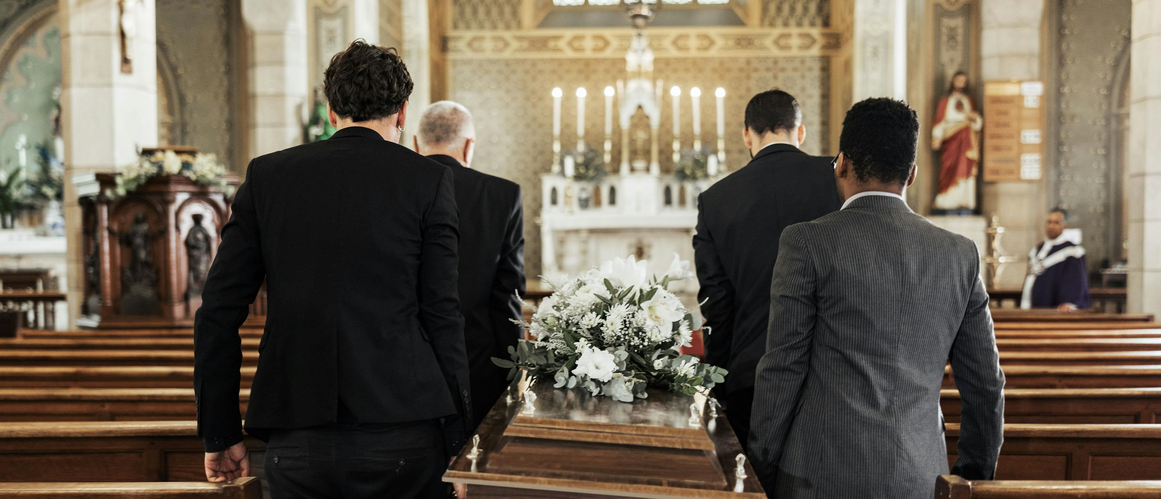 Eine religiöse Trauerfeier: Die Hinterbliebenen tragen den Sarg in die Kirche.&nbsp;
