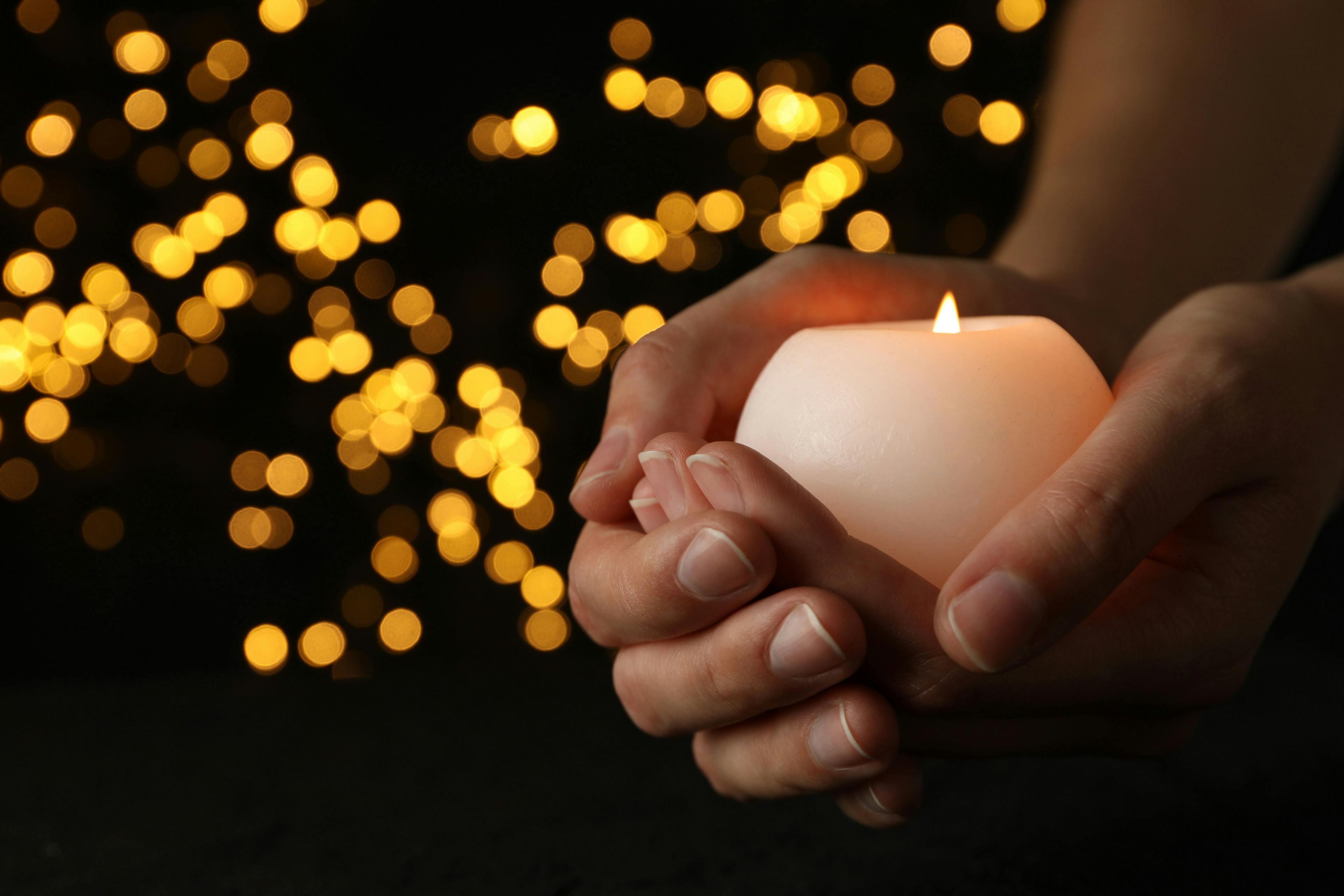 Trauersprüche: eine Kerze in einer Hand